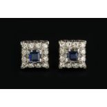 A PAIR OF SAPPHIRE AND DIAMOND CLUSTER EAR STUDS, each square step-cut sapphire claw set within a