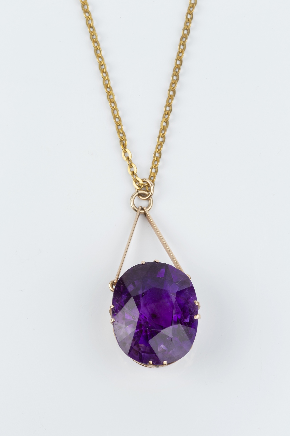AN AMETHYST SINGLE STONE PENDANT NECKLACE, the cushion-shaped mixed-cut amethyst in claw setting,