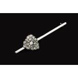 A DIAMOND HEART BAR BROOCH, the uniform bar obliquely applied with a heart-shaped panel of pavé