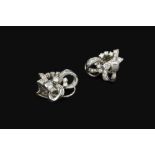 A PAIR OF DIAMOND EAR CLIPS, each designed as an openwork scrolled ribbon of graduated round