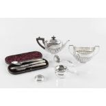 AN EDWARDIAN SILVER BACHELOR'S TEAPOT, of half lobed form, with ebonised handle and knop, by James