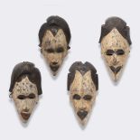 A SET OF FOUR WEST AFRICAN GABON MASKS, all carved from dark wood and having individual hair