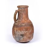 A ENGLISH MEDIEVAL POTTERY JUG, with slip and strap handle, 45cm high