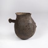 A EAST AFRICAN POURING VESSEL, Kenyan, wooden handle, molded face to one side 19cm high