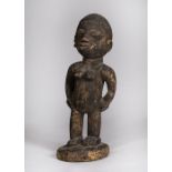 A WEST AFRICAN CARVED WOODEN FIGURE, circular base standing 56cm high