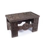 A WEST AFRICAN BENIN ALTAR TABLE, heavily carved wood, the surface carved with a scene of Oba and