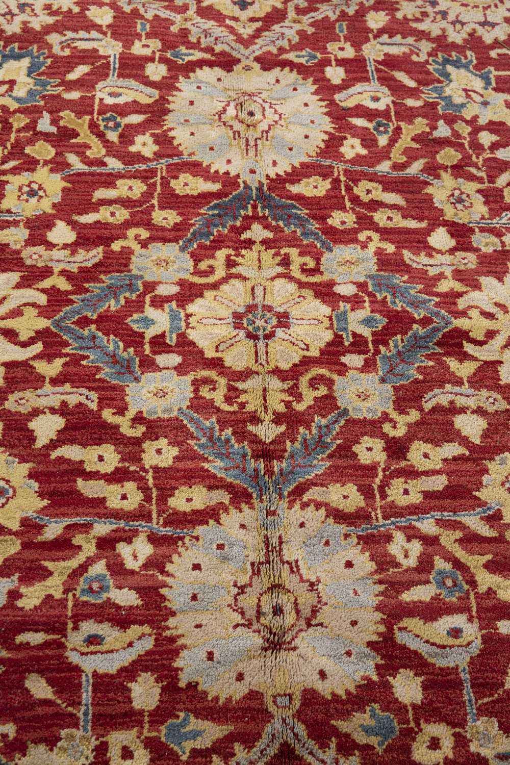 AN AGRA RED GROUND CARPET the repeating foliate and scroll motif within a dark blue ground border, - Image 4 of 5