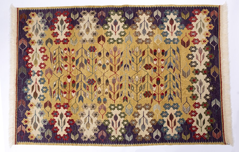 A TURKISH MULTICOLOURED KELIM with a continuing pattern of rosettes and arrows on a pale ochre