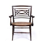 AN AESTHETIC LOW ARMCHAIR IN THE MANNER OF E.W. GODWIN, mahogany with caned seat, 19th Century, 74cm
