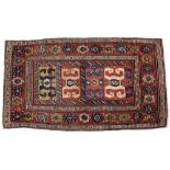 A TURKISH BERGAMA RED GROUND RUG decorated four panels of rams horn motifs with rosette border,