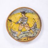 A 17/18TH CENTURY ITALIAN MONTELUPO MAIOLICA DISH, polychrome decorated with a soldier carrying a