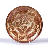 A EARLY HISPANO-MORESQUE COPPER LUSTRE DISH, decorated with central grape pattern, 20cm wide