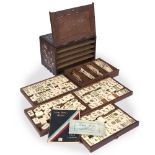 AN ANTIQUE CHINESE BONE AND SANDALWOOD MAHJONG SET contained within an inlaid cabinet with brass