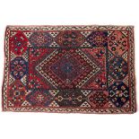 A TURKISH BERGAMA RED GROUND RUG with a central hooked medallion, 155cm x 103cm