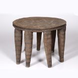 A NIGERIAN NUPE STOOL, carved wood with nine supporting legs 34cm high x 45cm wide