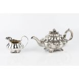 A WILLIAM IV SILVER TEAPOT of lobed and compressed form, the lobes with stylized leaf decoration,