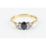 A SAPPHIRE AND DIAMOND THREE STONE RING, the oval mixed-cut sapphire claw set between two old-cut