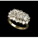 A DIAMOND CLUSTER RING, centred with a line of graduated baguette-cut diamonds in claw settings,