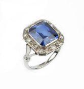 A SYNTHETIC SAPPHIRE AND DIAMOND CLUSTER RING, the octagonal mixed-cut synthetic sapphire collet set