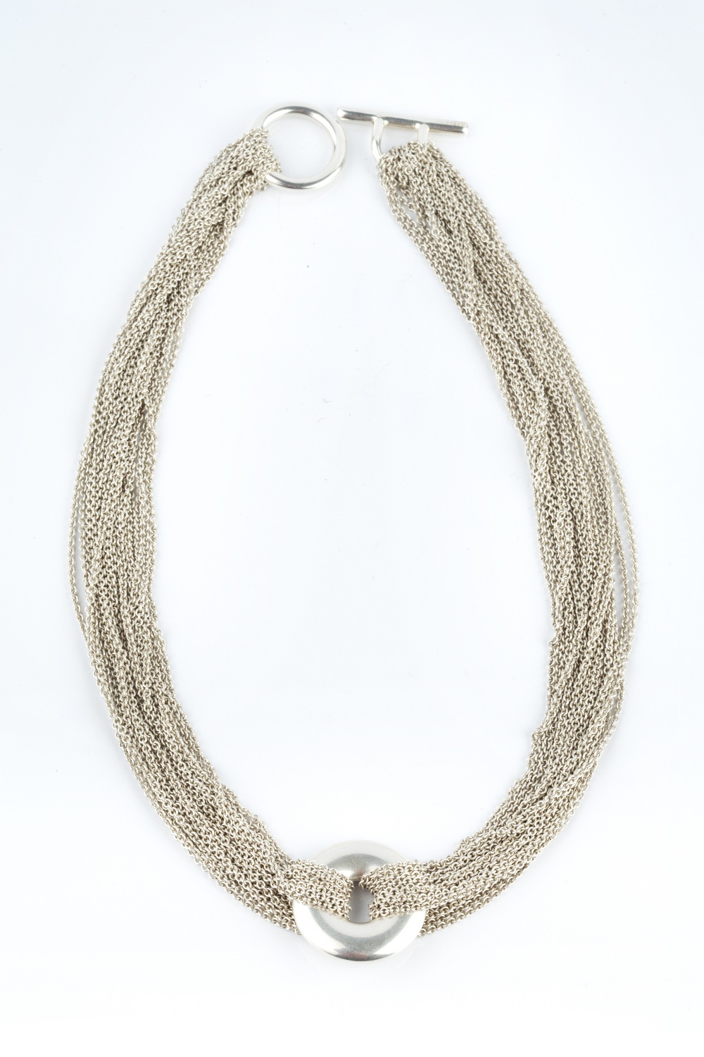 A COLLAR NECKLACE BY TIFFANY & CO., the multi-strand trace-link necklace with central circular panel