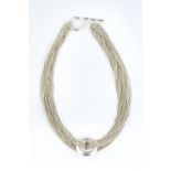 A COLLAR NECKLACE BY TIFFANY & CO., the multi-strand trace-link necklace with central circular panel