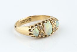 AN OPAL AND DIAMOND HALF HOOP RING, set with a trio of oval cabochon opals, spaced by pairs of