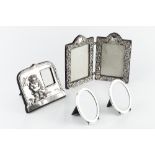 A LATE VICTORIAN SILVER MOUNTED RECTANGULAR DOUBLE PHOTO FRAME, the hinged frame pierce decorated