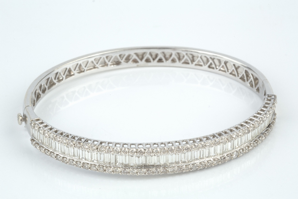 A DIAMOND BANGLE, of hinged oval form, channel set to the front with a line of baguette-cut - Image 2 of 5
