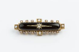 A LATE VICTORIAN DIAMOND AND HALF PEARL SET MEMORIAL BROOCH, the elongated oval black onyx panel
