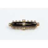 A LATE VICTORIAN DIAMOND AND HALF PEARL SET MEMORIAL BROOCH, the elongated oval black onyx panel