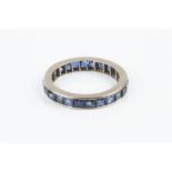 A SAPPHIRE FULL HOOP ETERNITY RING, channel set throughout with square step-cut sapphires, white