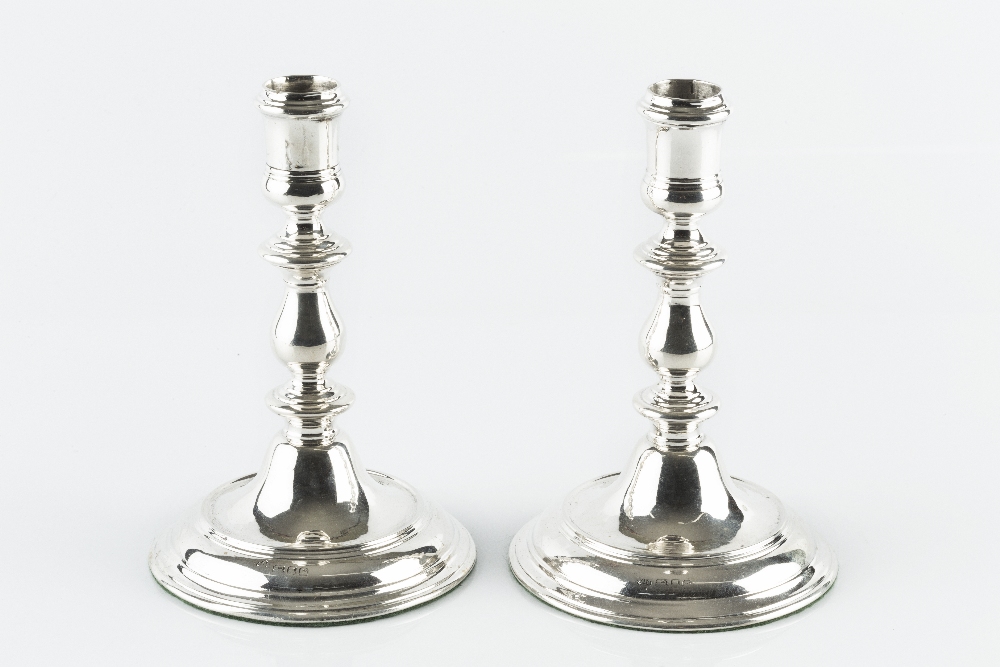 A PAIR OF SILVER CANDLESTICKS, with baluster knopped stems, and weighted circular bases, by Asprey &