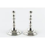 A PAIR OF SILVER CANDLESTICKS, with baluster knopped stems, and weighted circular bases, by Asprey &