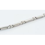 A DIAMOND SET BRACELET, designed as a line of baton-shaped panels of brushed finish, spaced by round