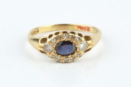 A SAPPHIRE AND DIAMOND CLUSTER RING, the oval mixed-cut sapphire bordered by round brilliant and