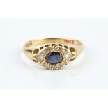 A SAPPHIRE AND DIAMOND CLUSTER RING, the oval mixed-cut sapphire bordered by round brilliant and