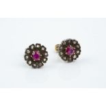 A PAIR OF RUBY AND DIAMOND CLUSTER EAR STUDS, each designed as a flowerhead cluster, centred with