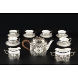 AN EDWARDIAN SILVER MOUNTED ROYAL WORCESTER TEA SERVICE, the porcelain decorated in green and puce