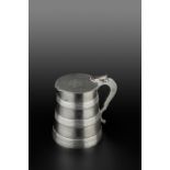 A GEORGE III SILVER TANKARD, the tapered body with bands of reeded decoration, the hinged top with