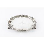 A LATE VICTORIAN SILVER SMALL SALVER, with shaped scroll and scallop cast border, on shaped feet,