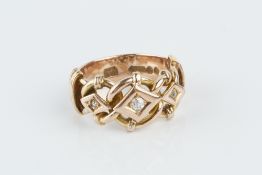 A LATE VICTORIAN DIAMOND DRESS RING, centred with a scrolled openwork panel, highlighted with a trio