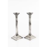 A PAIR OF SILVER CANDLESTICKS, the fluted columns with Corinthian capitals, and beaded stepped