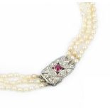 A CULTURED PEARL TRIPLE STRAND NECKLACE WITH RUBY AND DIAMOND SET CLASP, comprising three strands of