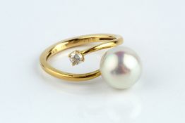 A CULTURED PEARL AND DIAMOND DRESS RING, of crossover design, yellow precious metal mounted, stamped