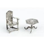 A LATE 19TH CENTURY GERMAN SILVER MINIATURE CHAIR, with open arms and tall panelled back, import