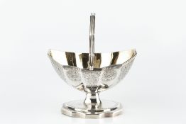 A GEORGE III SILVER SWING HANDLED SUGAR BASKET of faceted oval form, with reeded border and engraved