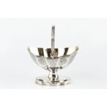 A GEORGE III SILVER SWING HANDLED SUGAR BASKET of faceted oval form, with reeded border and engraved