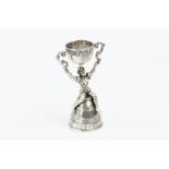 AN EARLY 20TH CENTURY CONTINENTAL SILVER SMALL WAGER CUP, modelled as a figure seated upon an