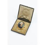 AN EARLY VICTORIAN PORTRAIT MINIATURE MEMORIAL BROOCH, the oval ivory panel painted to depict the