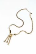A YELLOW PRECIOUS METAL PENDANT NECKLACE, circa 1940-50, the wishbone-shaped fluted panel suspending